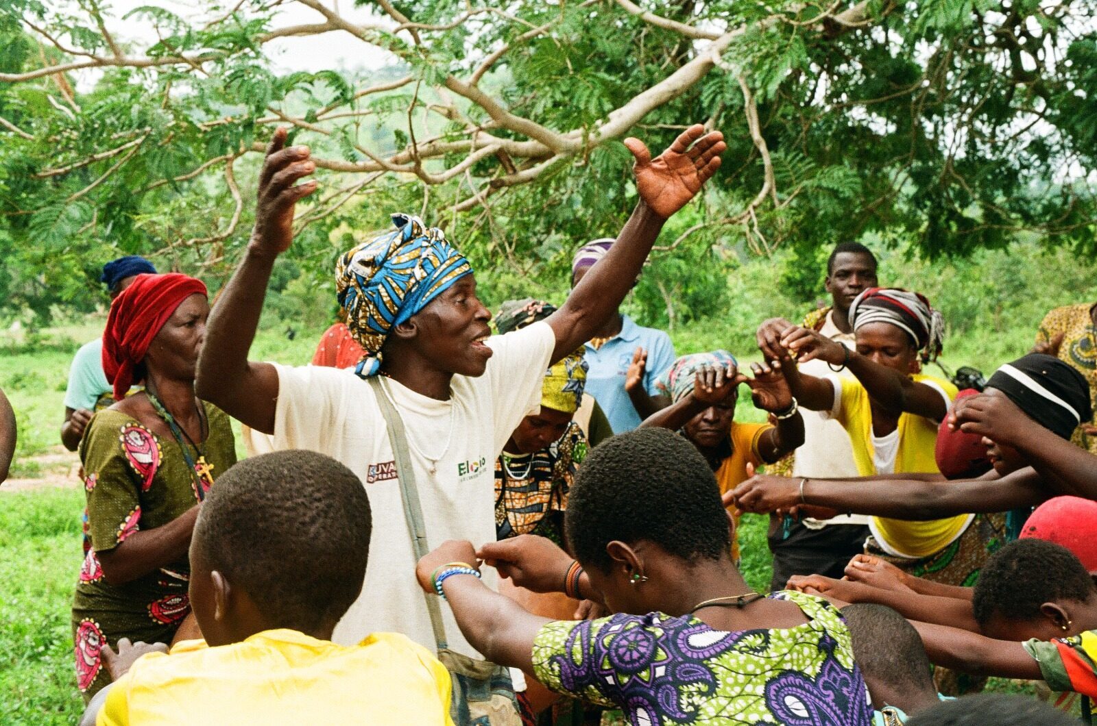 Femmes et enfants au Bénin sous un grand arbre vert